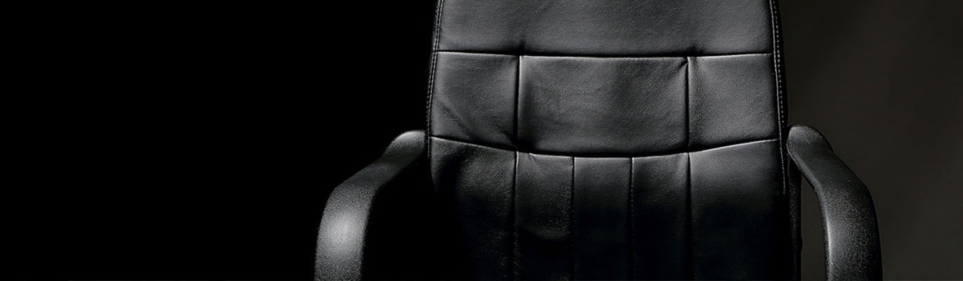 Black leather office chair on black