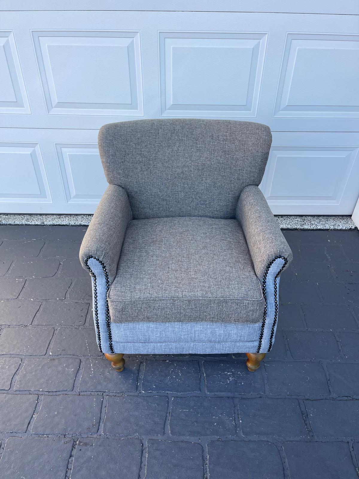 Gray upholstered armchair with wooden legs