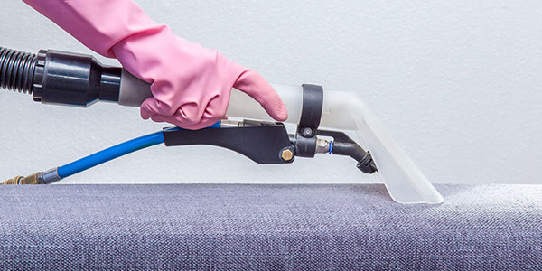 Hand using upholstery cleaning tool