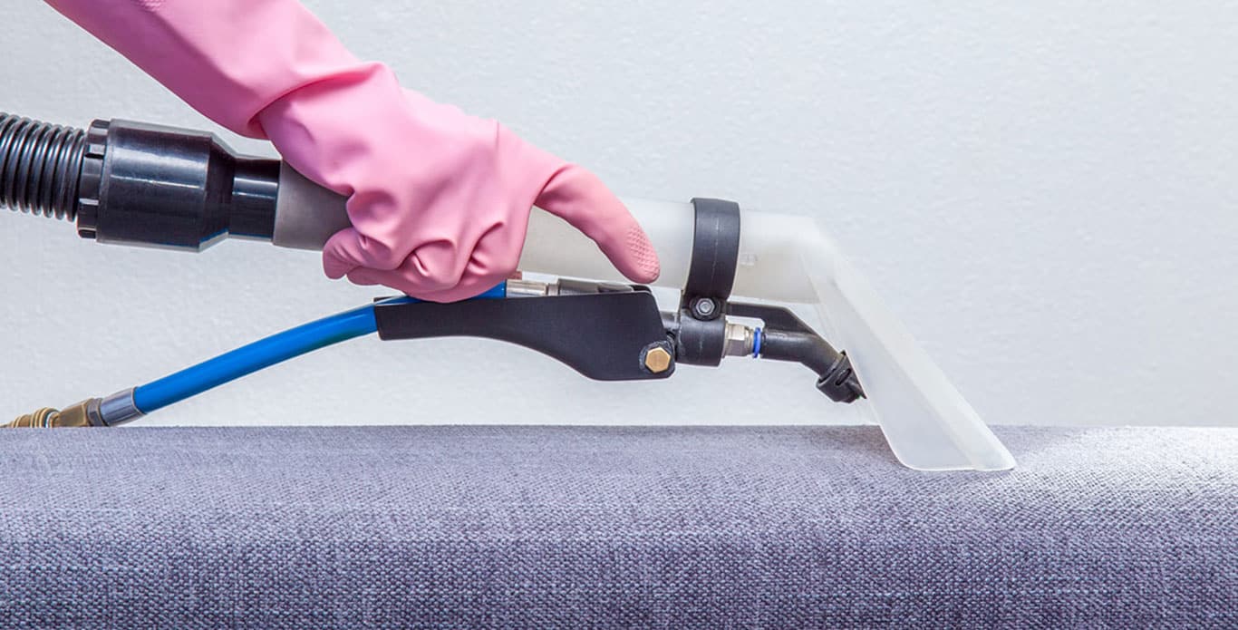 Hand using upholstery cleaning tool
