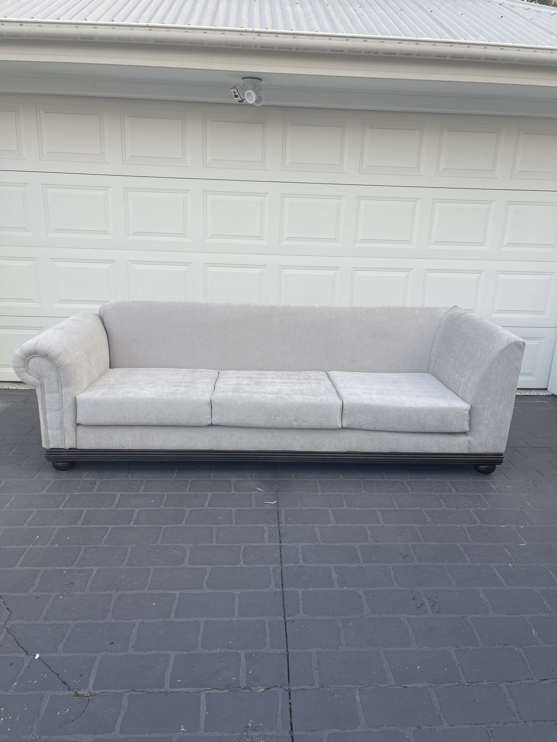 Light gray couch against garage door