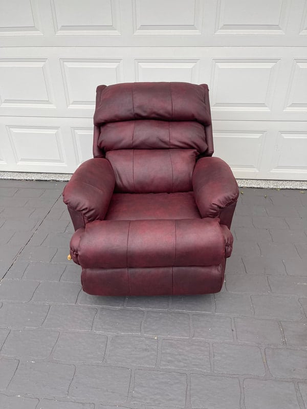 Maroon recliner chair on pavement