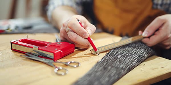 Person measuring fabric with tools