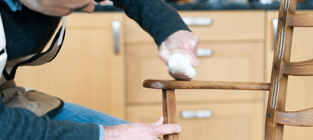 Person polishing wooden chair leg