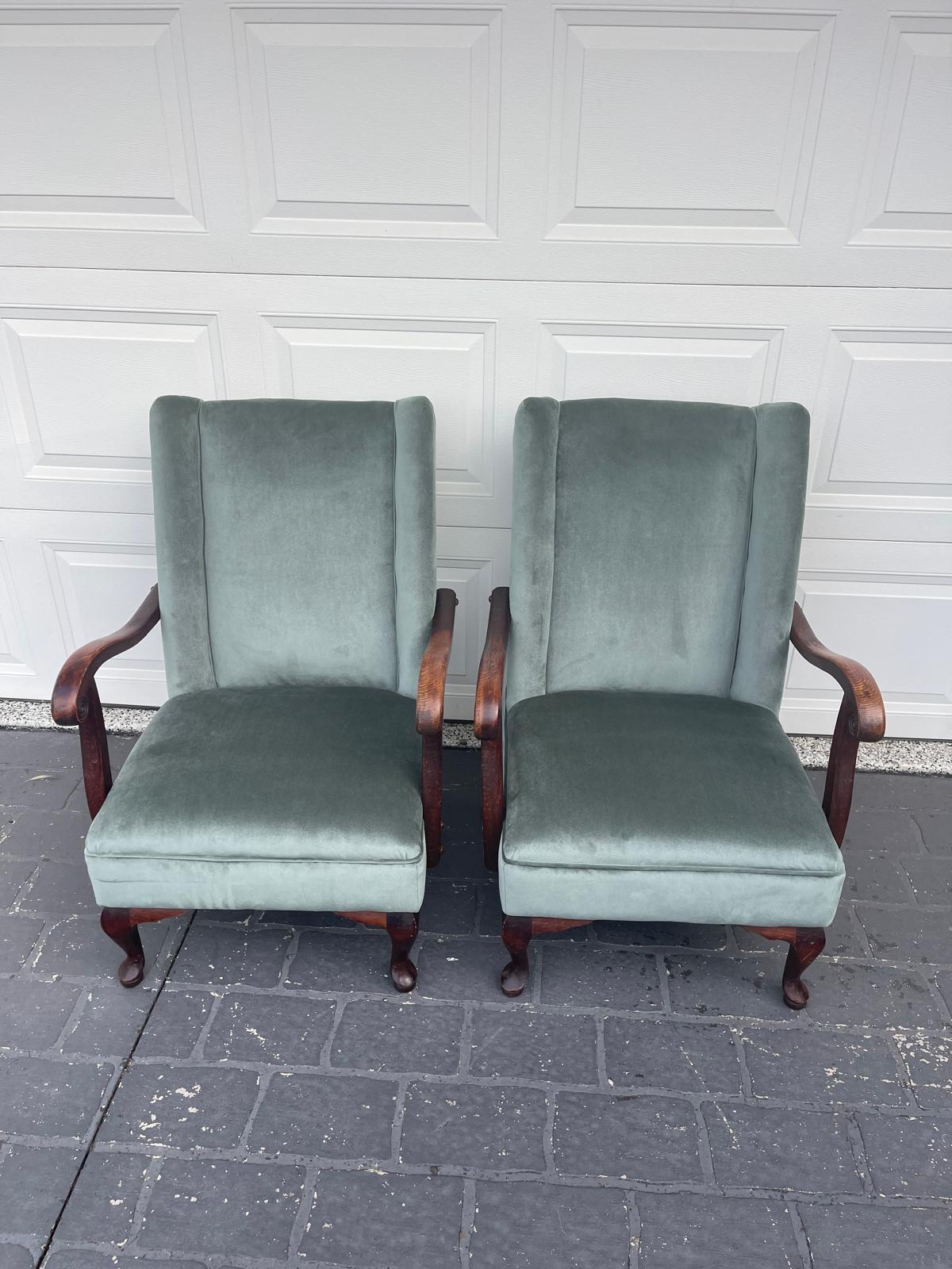 Two green upholstered armchairs on pavement