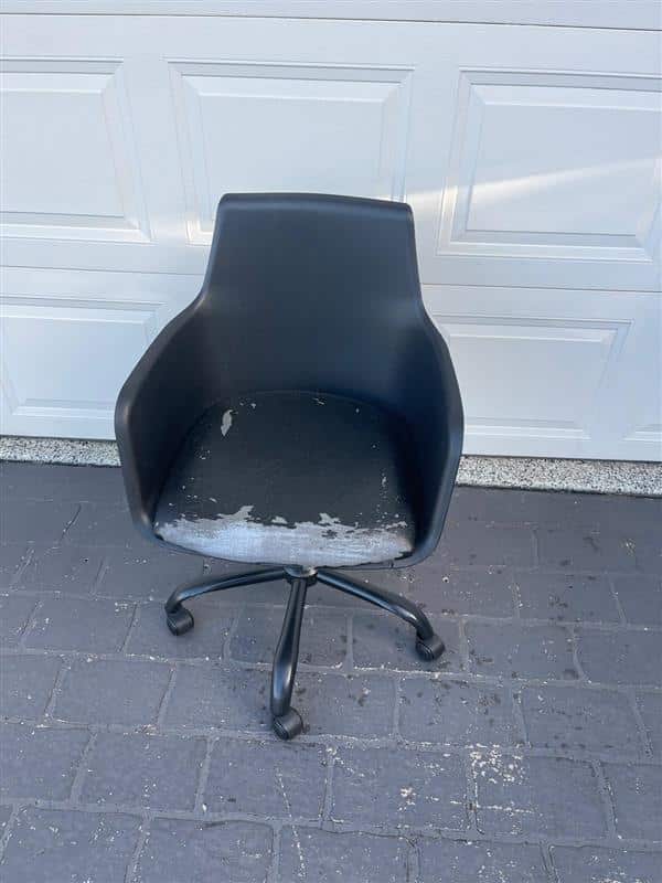 Worn black office chair on wheels