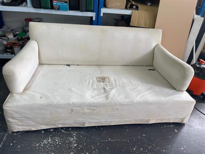 worn, white sofa with stains
