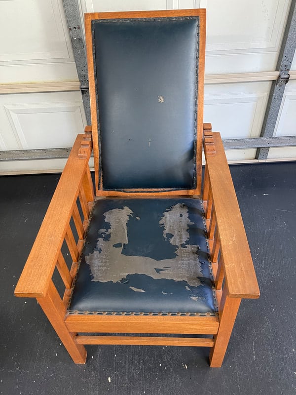 Worn wooden chair with damaged upholstery